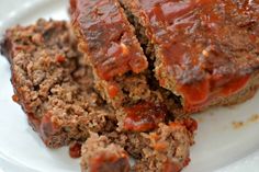 meatloaf with ketchup on top sitting on a plate