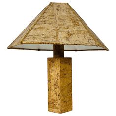 a lamp that is sitting on top of a wooden block with a glass shade over it