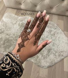 a woman's hand with henna tattoos on it