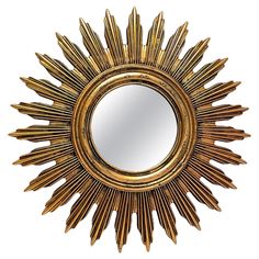 a gold sun mirror sitting on top of a white wall