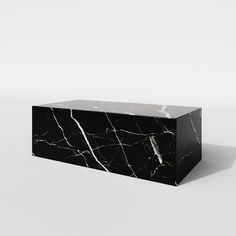 a black and white marble box sitting on top of a floor next to a wall