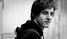 black and white photograph of a young man in a hoodie looking at the camera