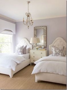 a bedroom with two beds and a chandelier