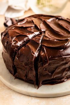 a large chocolate cake sitting on top of a white plate