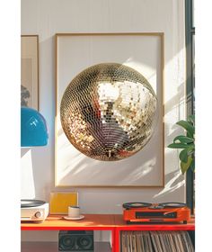 a mirror ball hanging on the wall next to a table with record players and records