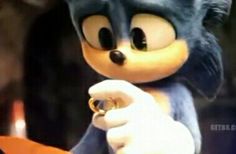 a close up of a sonic the hedgehog holding an orange object in his hand