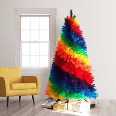 a brightly colored christmas tree sitting on top of a wooden floor