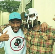 two men wearing masks pose for the camera