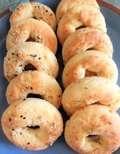 several bagels on a blue plate with sesame seeds