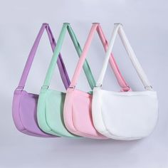 four different colored purses hanging from hooks