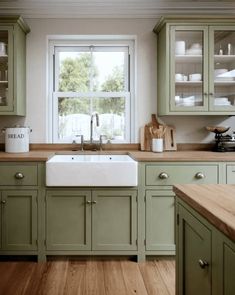 a kitchen with green cabinets and wooden floors