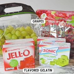 grapes, jello and gummy bears are sitting on the counter next to each other