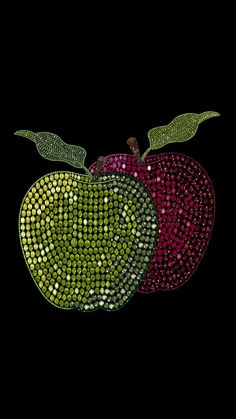 an apple with green and red diamonds on it's side, against a black background