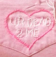 a pink heart with the words our dead 2 me written on it in white thread