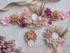 some pretty pink and brown flowers on a white wooden surface with ribbons, tags and bows