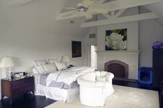 a bedroom with white furniture and a fireplace