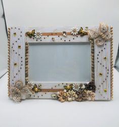 a white frame with flowers and pearls on it