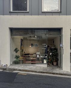 an empty store front with plants in the window