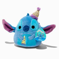 a blue stuffed animal with a party hat on it's head and purple ears