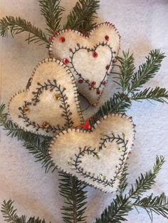 three heart shaped ornaments hanging from a tree