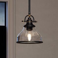 a light hanging from the ceiling in a room with a door and window behind it