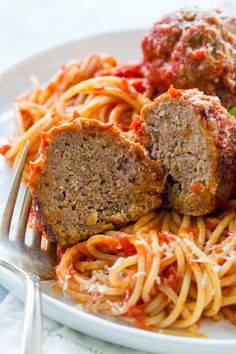 meatballs and spaghetti on a plate with a fork