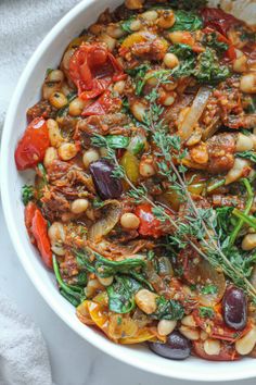 a white bowl filled with lots of different types of food on top of a table