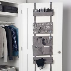 an organized closet with clothes hanging on the door and other items in front of it