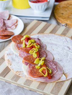 a wooden cutting board topped with slices of salami