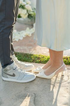 two people standing next to each other wearing white shoes