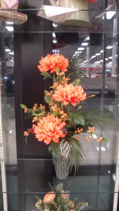 an arrangement of flowers in a glass case