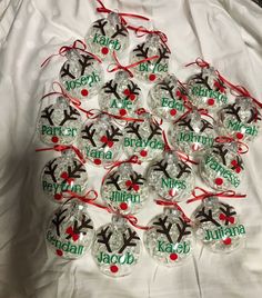 twelve personalized christmas baubles with reindeer heads and red ribbon on white fabric