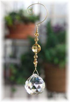 a close up of a wind chime hanging from a wire with a potted plant in the background