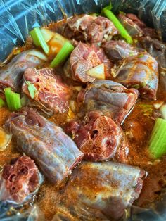 some meats and vegetables are in a bowl on top of plastic wrapper foil