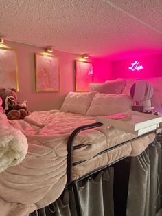 there is a bed with pink lights on the wall and teddy bears sitting on it