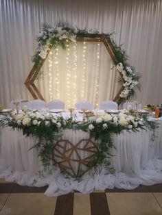 the table is set up with white flowers and greenery