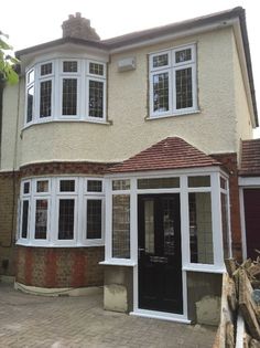 a large house with white windows and brick walkway leading up to the front door area