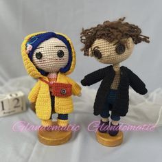 two crocheted dolls standing next to each other