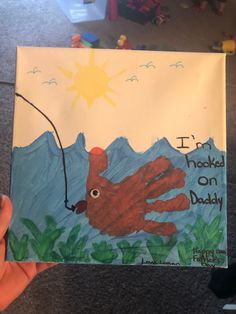 a child's hand holding up a card with an octopus on it and the words i'm hooked on daddy