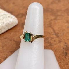 Estate/ vintage polished 10KT yellow gold ring with center, lab-created emerald + surrounding white diamonds. Timeless gold ring with a beautiful, vibrant green emerald! Size 7.25 Can be resized for an additional fee Weight: 1.8g (2) 1 pt genuine, white diamonds; SI clarity; H color Approx. 6mm x 4mm lab-created, green, rectangle center emerald Excellent estate condition Emerald Diamond Ring, Lab Created Emerald, Green Emerald, Yellow Gold Ring, Vibrant Green, Emerald Diamond, White Diamonds, Yellow Gold Rings, Ring Holder