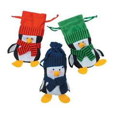 three stuffed penguins wearing hats and scarfs