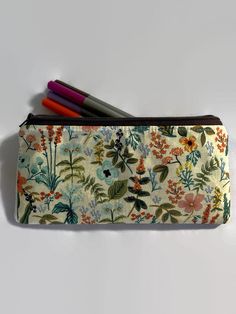 "This listing has six options to choose from. All pouches are made with a high quality Rifle Paper fabric print on the outside.  Interfaced for stability. Secured with a quality zipper. The inside is lined with 💯 cotton fabric. Dimensions: 9\" in length x 5\" in length. Perfect as a pencil case, cosmetics case, cash holder or accessory pouch.  Care: wash in a gentle cycle using cold water and air dry for best results.  Thank you for visiting Gratitude Oasis." Cotton Pencil Case, Green Pencil Case With Pen Holders For Storage, Green Pencil Case With Pen Holders, Green Pencil Case Pouch With Pen Holders, Pencil Case Pouch With Pen Holders, Pencil Case With Pen Holders Pouch For Storage, Pencil Case With Pen Holders, Rectangular Storage Pouch With Pen Holders, Pencil Case With Zipper Pouch For Personal Use