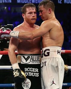 two men standing next to each other with boxing gloves on their shoulders and one holding his arm around the other man's shoulder