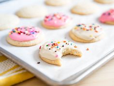 a tray filled with frosted donuts and sprinkles