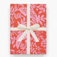 a wrapped gift box with pink and white floral designs on it, tied with a ribbon