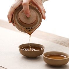 a person pouring water into a bowl on top of a table