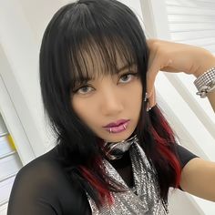 a woman with red and black hair posing for the camera