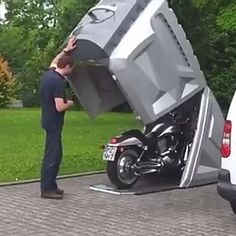 a man standing next to a parked motorcycle