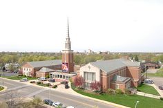 an aerial view of a church with cars parked on the street in front of it