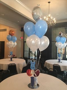 balloons and basketballs are on the table at a sports themed birthday party in an office building